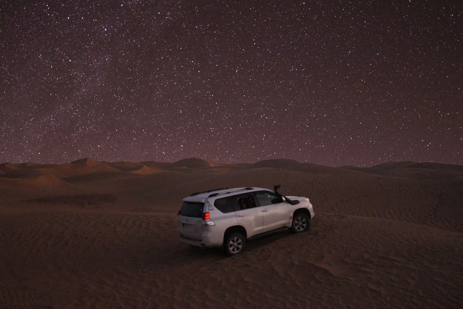 Nuit étoilée dans le désert 4x4 blanc stationné dans le désert sous un ciel nocturne étoilé