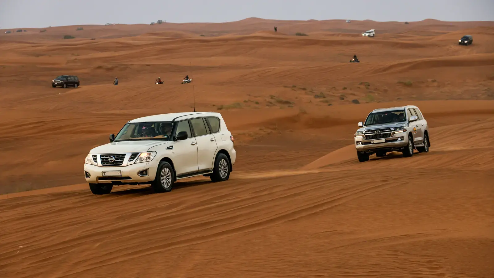 Deux véhicules 4x4 blancs traversant les dunes